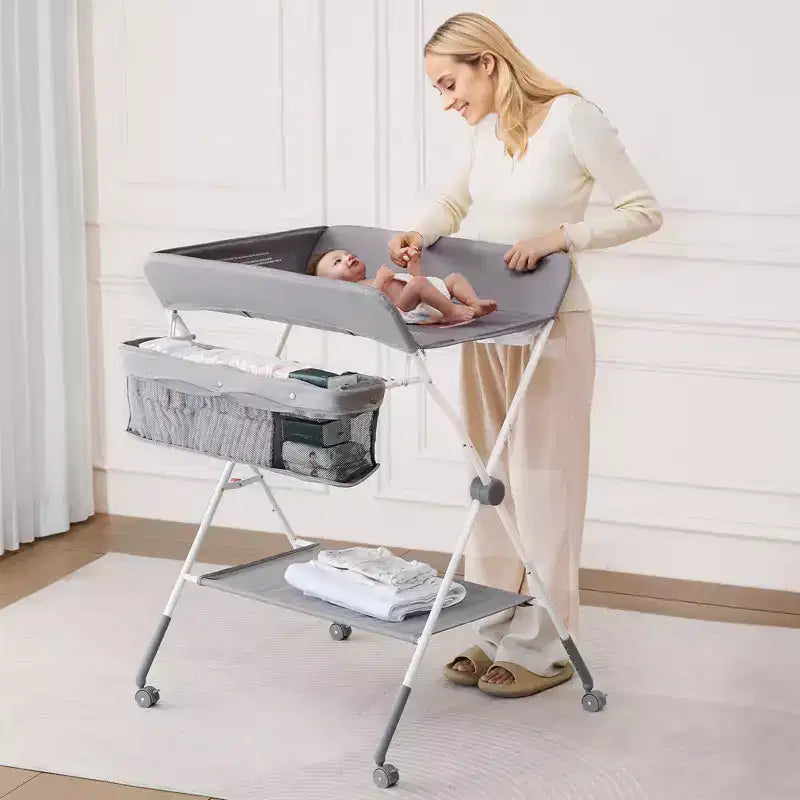 Table à langer pliable avec panier latéral, roulettes verrouillables, gris clair